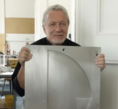 Leonid Bunimovich holding a model of a Bunimovich mushroom used in an experimental device in a physics lab.