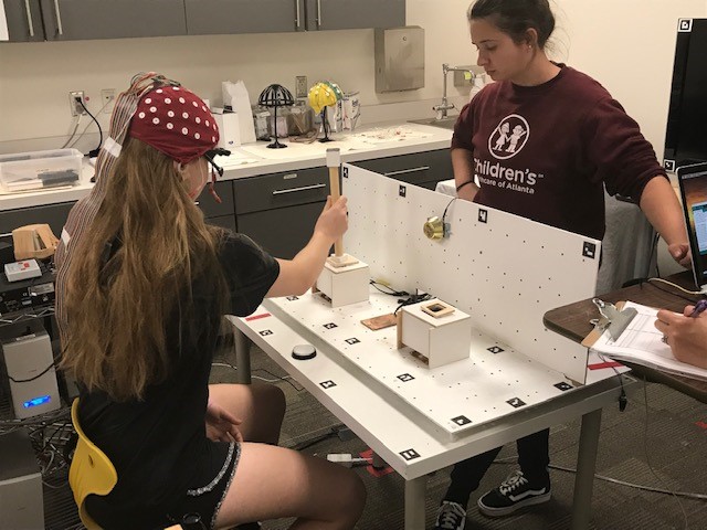 Olivia Cox (left) participates in a Cognitive Motor Control Lab eye tracking study while Kristina Giddens looks on (Photo by Renay San Miguel.) 